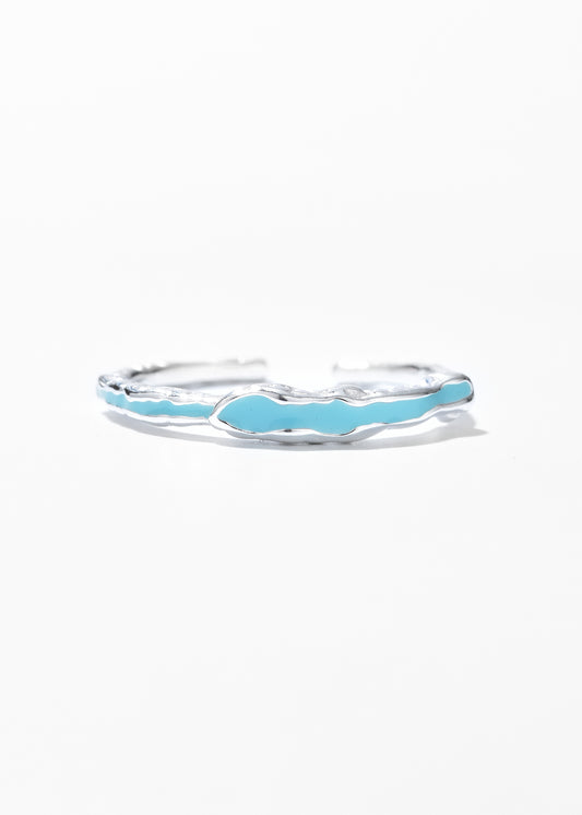 A wavy drip ring with a glossy turquoise enamel inlay.