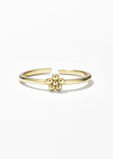 A gold-tone open ring with a small, detailed flower design at the top.