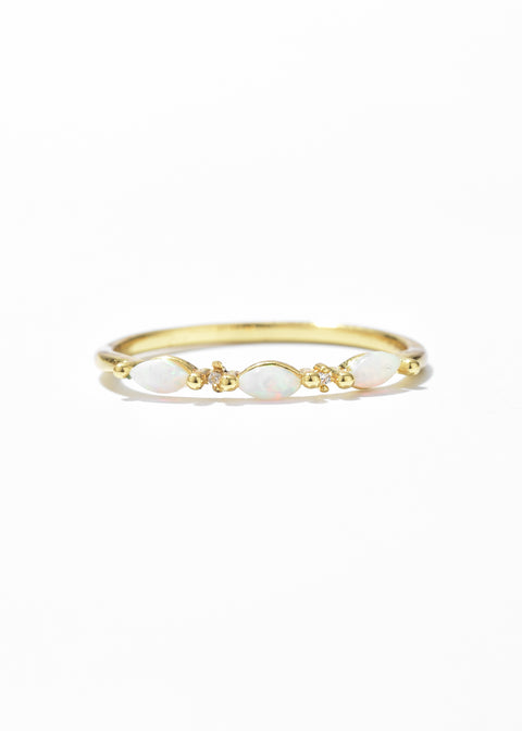 A gold stone ring featuring a series of oval opals, interspersed with tiny gold beads.