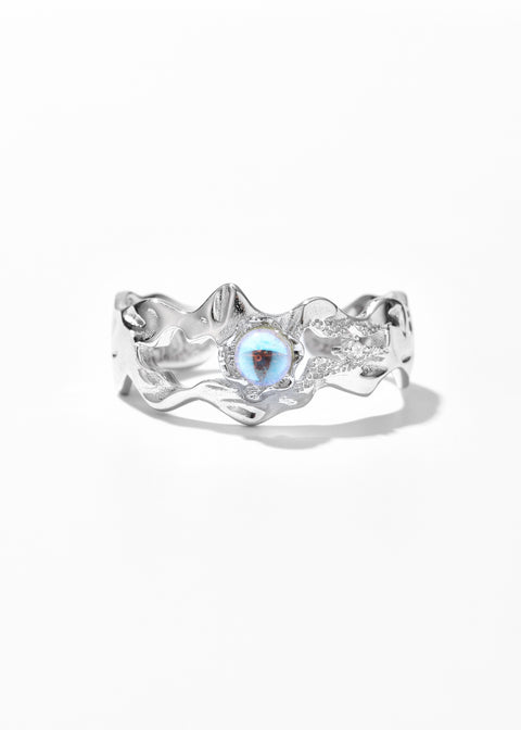 A silver ring with a wavy, flowing design and a small, iridescent opal set in the center.A silver wave ring with a flowing design and a small, iridescent opal set in the center.