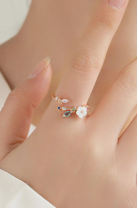 An open-ended floral ring band, accented by a cluster of multicolored gemstones.