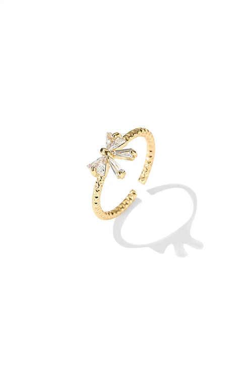 Bowtie sparkle ring accented with small sparkling gems on a slender gold band.