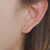 Wimsico pink stone heart gold diamond earring placed on the earlobe is showcased