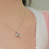 A dainty flower necklace featuring three small floral charms hanging from a chain.