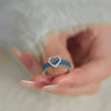 A heart shaped ring with a denim band setting encrusted with sparkling small stones.