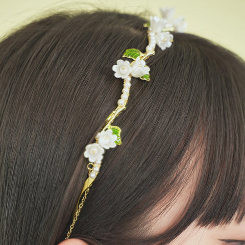 A flower headband with floral details and small white pearls.