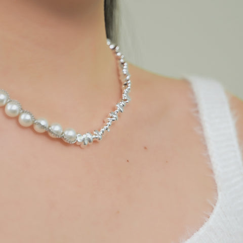 A bead necklace with silver beads and glass pearls.