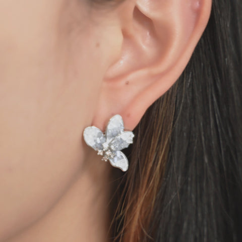 Flower stud earrings with blue crystal petals and a shiny center.