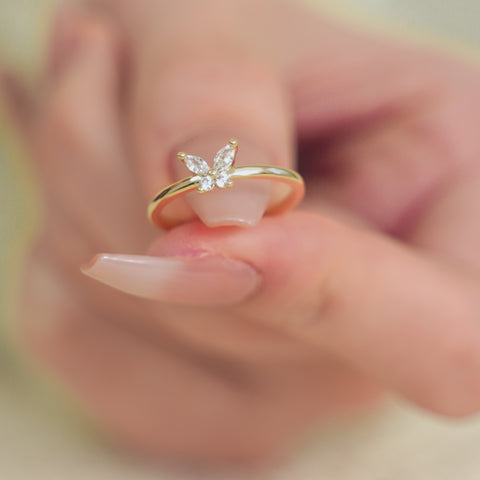 A butterfly mood ring with a gold band centered by round stone.